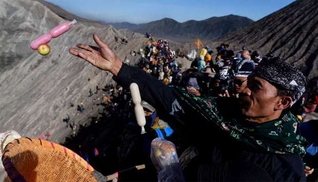 Worshippers throw offerings into the volcanic crater of Mount Bromo