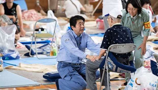 Japan's Prime Minister Shinzo Abe visits a shelter for people affected by flooding in Mabi, Okayama prefecture on Wednesday.