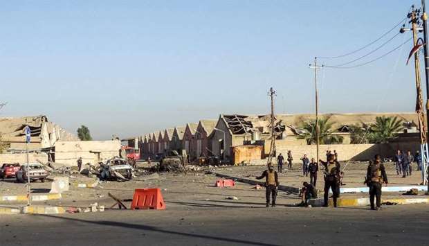 Members of the Iraqi Counter-Terrorism Service (CTS) stand at the scene of an attack outside warehouses where ballots from the May 12 parliamentary vote were stored in the northern multi-ethnic city of Kirkuk