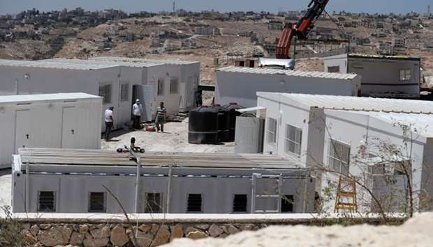 Israeli workers place container houses near the town of Al-Eizariyah in the occupied West Bank near East Jerusalem.