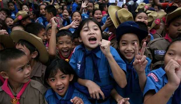 Students celebrate in front of Chiang Rai Prachanukroh hospital, where the 12 soccer players and their coach rescued from the Tham Luang cave complex are being treated, in the northern province of Chiang Rai on Wednesday.
