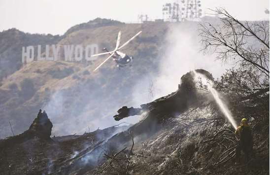 Firefighters battle the Griffith fire at Griffith Park near the historic Griffith Observatory and the iconic Hollywood sign in Los Angeles on Tuesday.