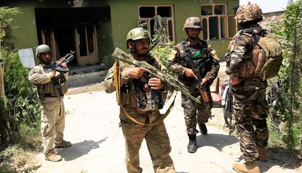 Afghan security forces personnel inspect a site after an attack