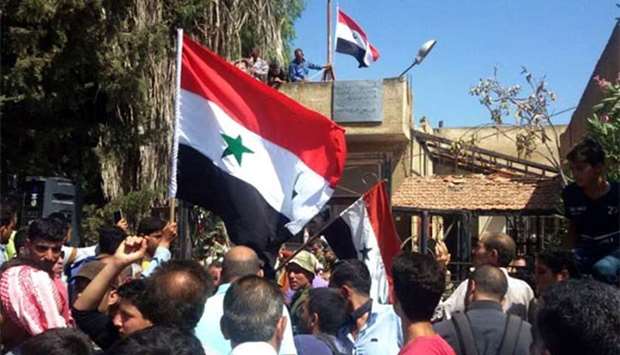 Syrians waving their national flag near the city council in Deraa countryside.