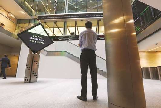 A visitor looks at a ticker of share prices at the London Stock Exchange (file). The FTSE 100 closed down 1.3% to 7,591.96 points yesterday.