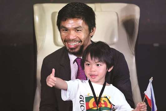 Philippineu2019s Manny Pacquiao smiles with his son Israel during a press conference in Kuala Lumpur yesterday. (AFP)