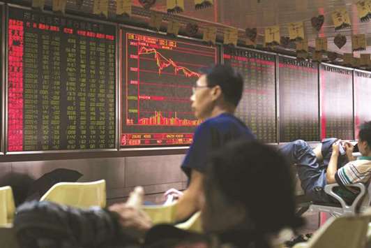 People sit in front of a screen showing stock prices at a securities company in Beijing. Shanghai index jumped 2.2% to 2,837.66 as the Chinese central bank set the struggling yuanu2019s dollar fix at a strong level in a bid to soothe concerns about its recent sell-off.