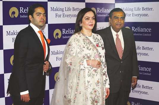 Mukesh Ambani, chairman and managing director of Reliance Industries, poses with his wife Nita Ambani and son Anant Ambani before addressing the companyu2019s annual general meeting in Mumbai. Reliance is the second Indian corporate after Tata Consultancy Services to surpass $100bn mark.