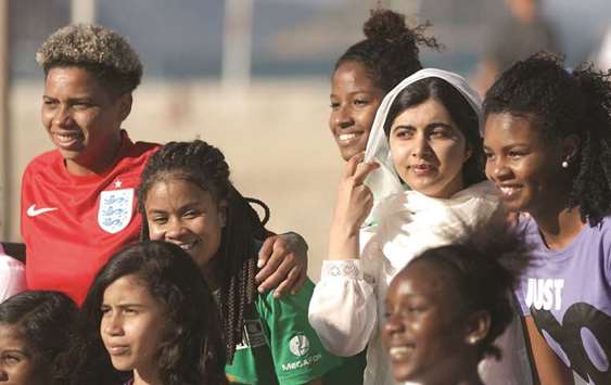 Yousafzai with teenage girls from Complexo da Penha, who work with football organisation Street Child United, at Copacabana beach in Rio de Janeiro.