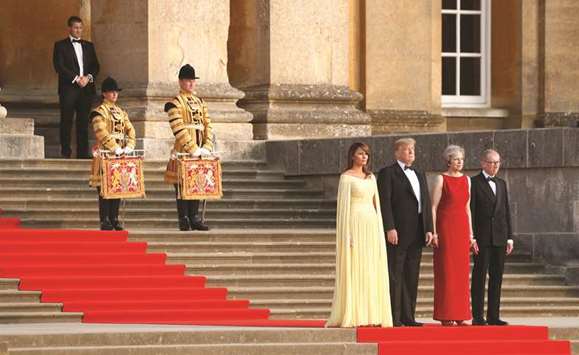 Prime Minster Theresa May and her husband Philip stand together with US President Donald Trump and First Lady Melania Trump at the entrance to Blenheim Palace, where they later attended a dinner with specially invited guests and business leaders, near Oxford, Britain, yesterday.