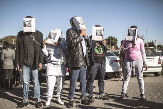 Members of the radical group u2018Black First Land Firstu2019 wear masks of former South African president F W de Klerku2019s portrait to demonstrate in support of Duduzane Zuma, son of former South African president Jacob Zuma, ahead of his appearance at the Randburg Magistrates Court in Johannesburg.