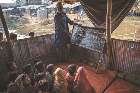 An Islamic teacher instructs a group of Rohingya children in a community madrassa in Balukhali refugee camp in Bangladesh. With no formal education available, Rohingya parents in the camps often send their kids to makeshift madrassas.