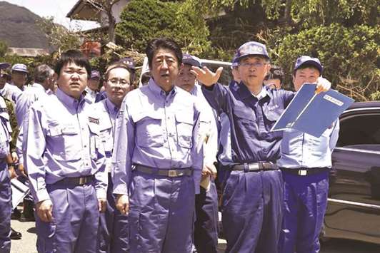 Japanu2019s Prime Minister Shinzo Abe inspects a flood-hit area in the city of Seiyo, Ehime prefecture, yesterday.