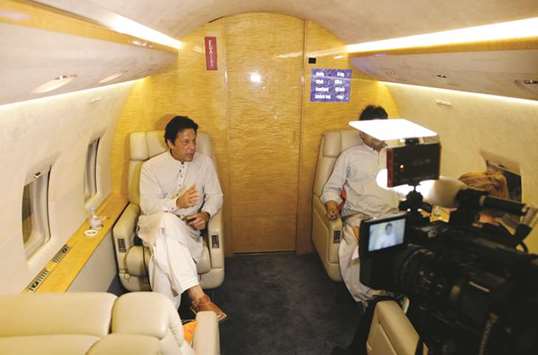 Khan gestures as he speaks during an interview with Reuters on a plane after a campaign rally ahead of general elections in Narowal.