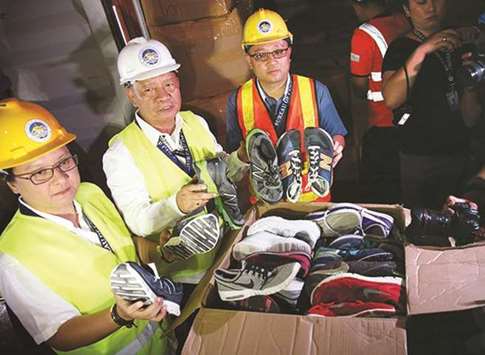 Customs Commissioner Isidro Lapena and other officials show to media smuggled shoes confiscated by the government at the Manila International container port.