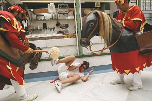 u2018Zaldikosu2019 (men in horse costumes) hit a boy with their sponge flails during the San Fermin festivalu2019s u2018Comparsa de gigantes y cabezudosu2019 (Parade of the Giants and Big Heads) in  Pamplona.