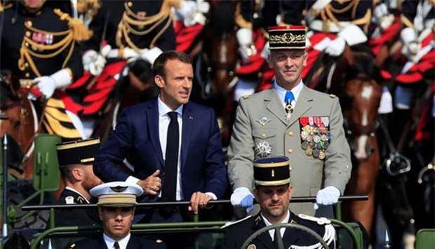 French President Emmanuel Macron and Chief of the Defence Staff French Army General Francois Lecointre arrive in a command car for the traditional Bastille Day military parade on Champs-Elysees in Paris on Saturday.