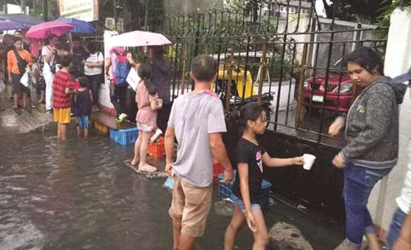 As cases of leptospirosis increase, a makeshift bridge is offered to passersby, to avoid walking through floodwaters on Taft Avenue in Manila.