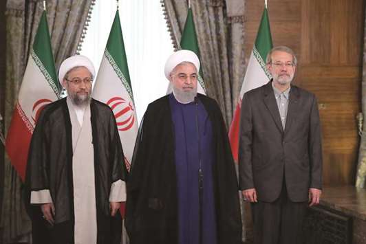 A handout picture provided by the Iranian presidency shows the Iranian judiciary chief Sadegh Larijani (left), Iranian president Hassan Rouhani and the parliament speaker Ali Larijani (right) during a meeting in Tehran, yesterday.