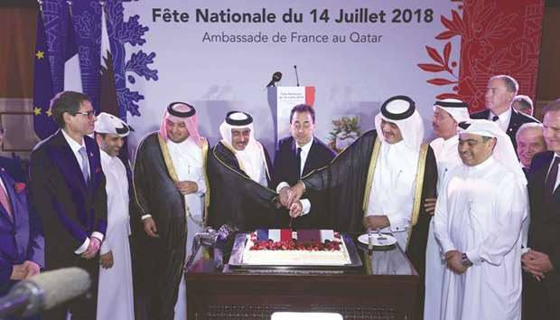 HE the Minister of Municipality and Environment Mohamed bin Abdullah al-Rumaihi and HE the Minister of Transport and Communications Jassim Seif Ahmed al-Sulaiti join ambassador Eric Chevallier in cutting the ceremonial cake in the presence of other dignitaries during the French National Day celebrations in Doha yesterday.