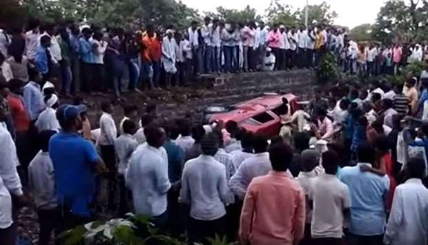Image grab from a video posted online shows a mob gathering around the car that fell in a ditch.