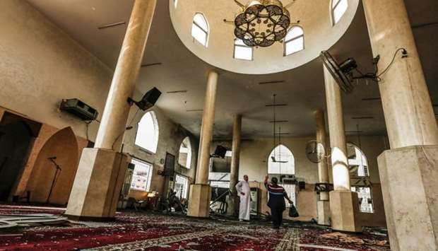Palestinian men inspect damages to a mosque that was hit by Israeli air strikes the day before in Gaza City.
