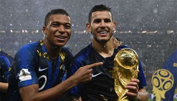 France stars Kylian Mbappe (left) and Lucas Hernandez pose with the World Cup trophy after their victory over Croatia at the Luzhniki Stadium in Moscow on Sunday.