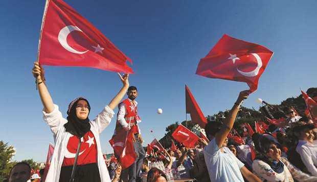 People wave Turkeyu2019s national flags as they arrive to attend a ceremony marking the second anniversary of the attempted coup at the Bosphorus Bridge in Istanbul yesterday.