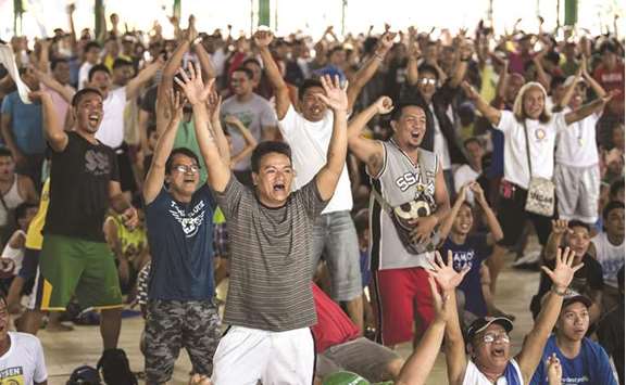 Filipino fans react as they watch Manny Pacquiao fight Argentinau2019s Lucas Matthysse during their world welterweight boxing championship bout in Kuala Lumpur, at a basketball court in Manila, yesterday.