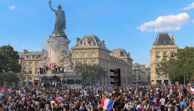 People celebrate France's victory in the Russia 2018 World Cup final football match between France and Croatia, on the Place de la Republique