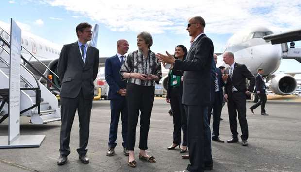 Britain's Prime Minister Theresa May (C) is accompanied by Airbus CEO Tom Enders (R) on her arrival at the Farnborough Airshow, south west of London