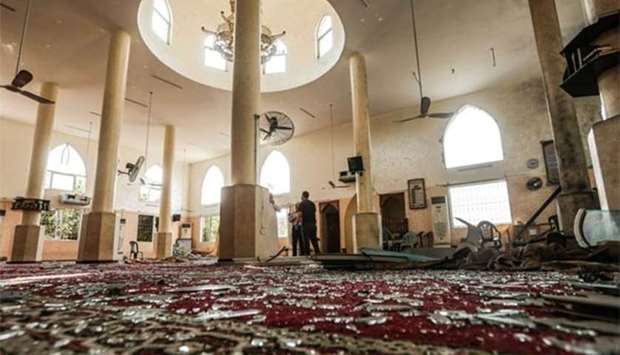 Palestinian men inspect damages to a mosque that was hit by Israeli air strikes the day before in Gaza City on Monday.