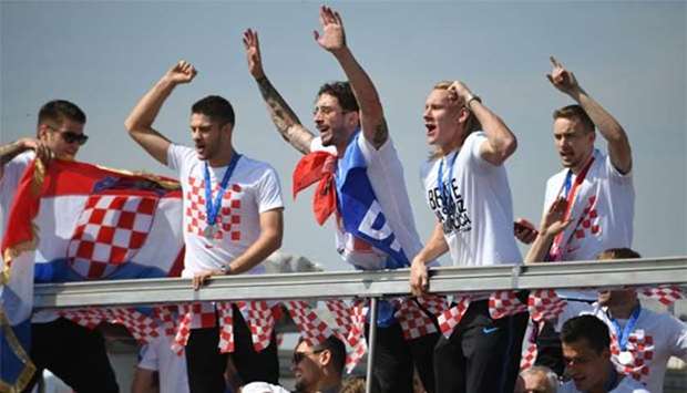 Croatian players ride an open-roof coach in Zagreb on Monday after their return from the FIFA World Cup in Russia.