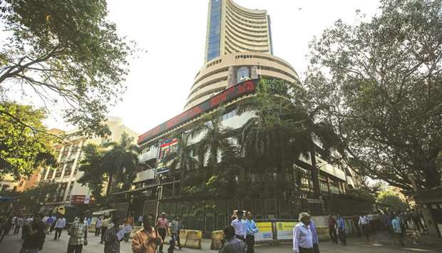 People walk by the Bombay Stock Exchange building in Mumbai (file). The BSE Sensex closed down 217.86 points to 36,323.77 yesterday.