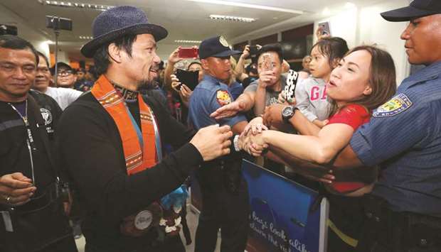 Philippine boxing icon Manny Pacquiao (centre) is greeted by fans after arriving from Malaysia, at a mall in General Santos City, in southern island of Mindanao. (AFP)