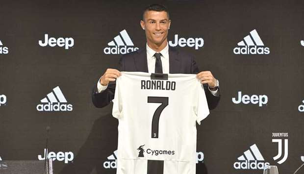 Cristiano Ronaldo pose with his jersey at a press conference, where he was unveiled as a Juventus player, in Turin, Italy, yesterday.