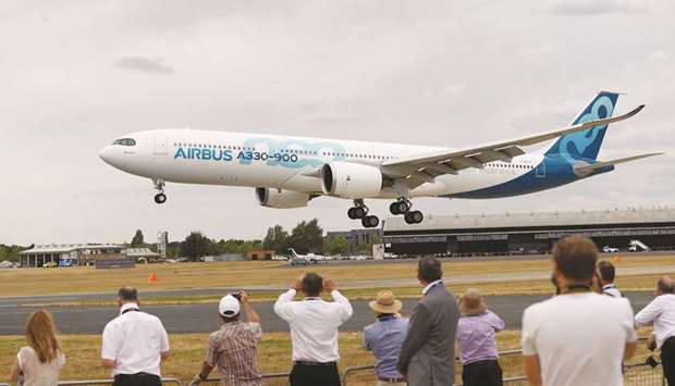 Spectators look at an Airbus A330-900 at the air show in Farnborough. Planemakers racked up more than $20bn of deals on the opening day of the air show yesterday, suggesting demand for new passenger jets remains in rude health despite worries over trade tensions and Brexit.