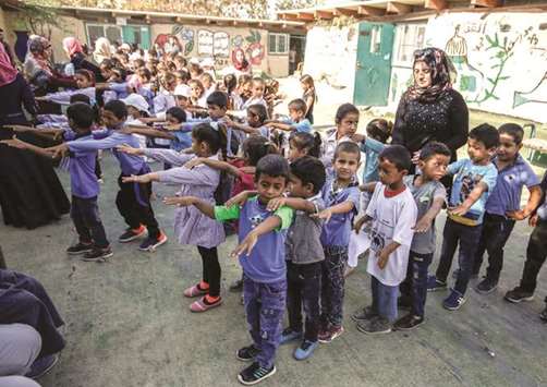 Palestinian children queue up before the early start of classes at a school in the Bedouin village of Khan al-Ahmar in the occupied West Bank, yesterday.