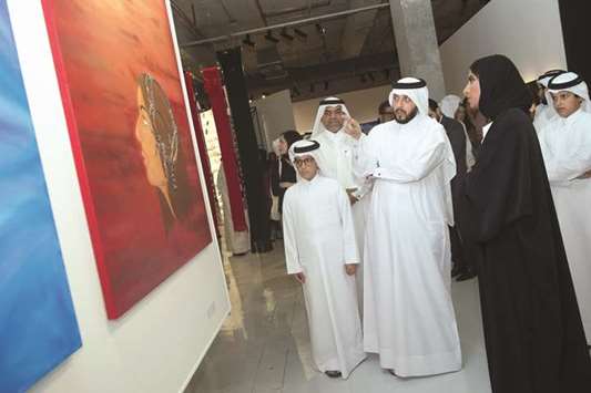 This picture supplied by Qatar Museums (QM) shows QM officials and other dignitaries discussing one of the works at the exhibition following its opening.