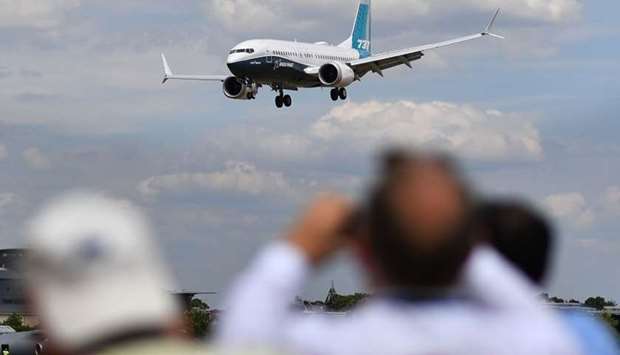 Visitors watch as a Boeing 737 Max lands after an air display