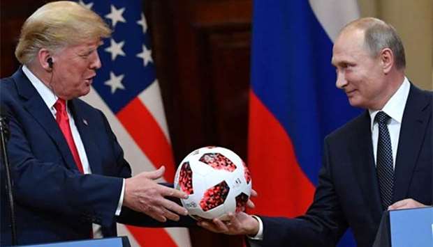 Russian President Vladimir Putin offers a ball of the 2018 football World Cup to US President Donald Trump during a joint press conference in Helsinki on Monday.