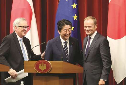 Japanese Prime Minister Shinzo Abe (centre), European Commission president Jean-Claude Juncker (left) and European Council president Donald Tusk smile after their joint press conference of Japan-EU summit at Abeu2019s official residence in Tokyo yesterday. Japan and the European Union signed a wide-ranging free trade deal yesterday that both sides hope will act as a counterweight to the protectionist forces unleashed by US President Donald Trump.