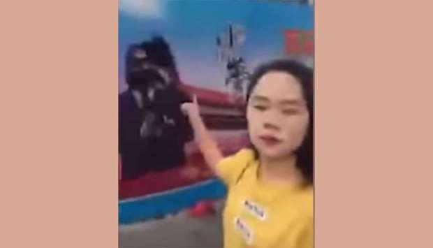 An image grab from a video uploaded on YouTube that shows Dong Yaoqiong pointing at a poster of Xi Jinping after throwing ink at it.