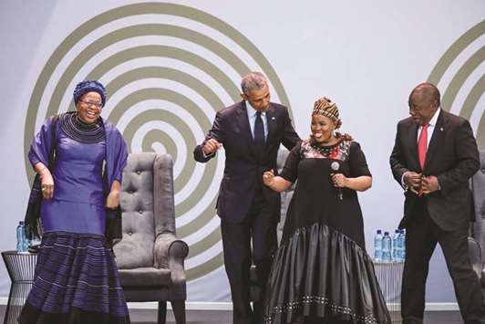 Former US president Barack Obama , Graca Machel (left), widow of former South African president and global icon Nelson Mandela, and South African President Cyril Ramaphosa (right) dance as South African singer Thandiswa Mazwai (second right) performs during the 2018 Nelson Mandela Annual Lecture at the Wanderers cricket stadium in Johannesburg, yesterday.
