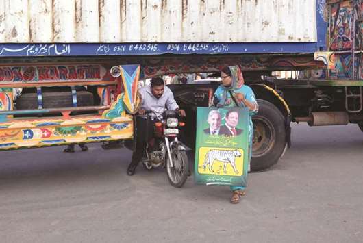 This picture taken on Friday shows a motorcyclist slipping through a gap in a barricade set up using shipping containers, near Lahore airport, to block supporters of Pakistan Muslim League u2013 Nawaz.