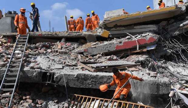 Members of the National Disaster Response Force (NDRF), along with local police, search for victims after an under construction building collapsed in the village of Shah Beri village in Greater Noida, a satellite town east of the Indian capital, in Uttar Pradesh.