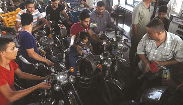 Palestinians wait to fill their motorcycles with fuel after Israel stopped the transfer of fuel and cooking gas into Gaza, at a petrol station in Khan Younis in the southern Gaza Strip, yesterday.