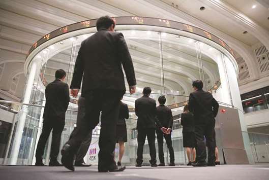 Visitors watch share prices at the Tokyo Stock Exchange. The Nikkei 225 closed up 0.4% to 22,794.19 points yesterday.
