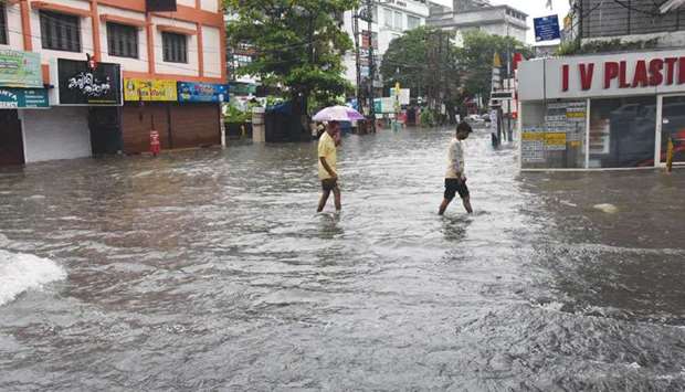 Two men make their way through a flooded street in Kochi.