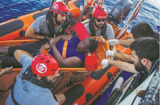 Marc Gasol (third from right wearing sunglasses) helps with a rescue effort in the Mediterranean. (Reuters)